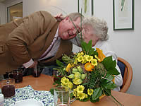 Bürgermeister Wind überreicht der ältesten Bürgerin Garstedts (Angela Wendler) anlässlich des Burn Räken einen Blumenstrauß.